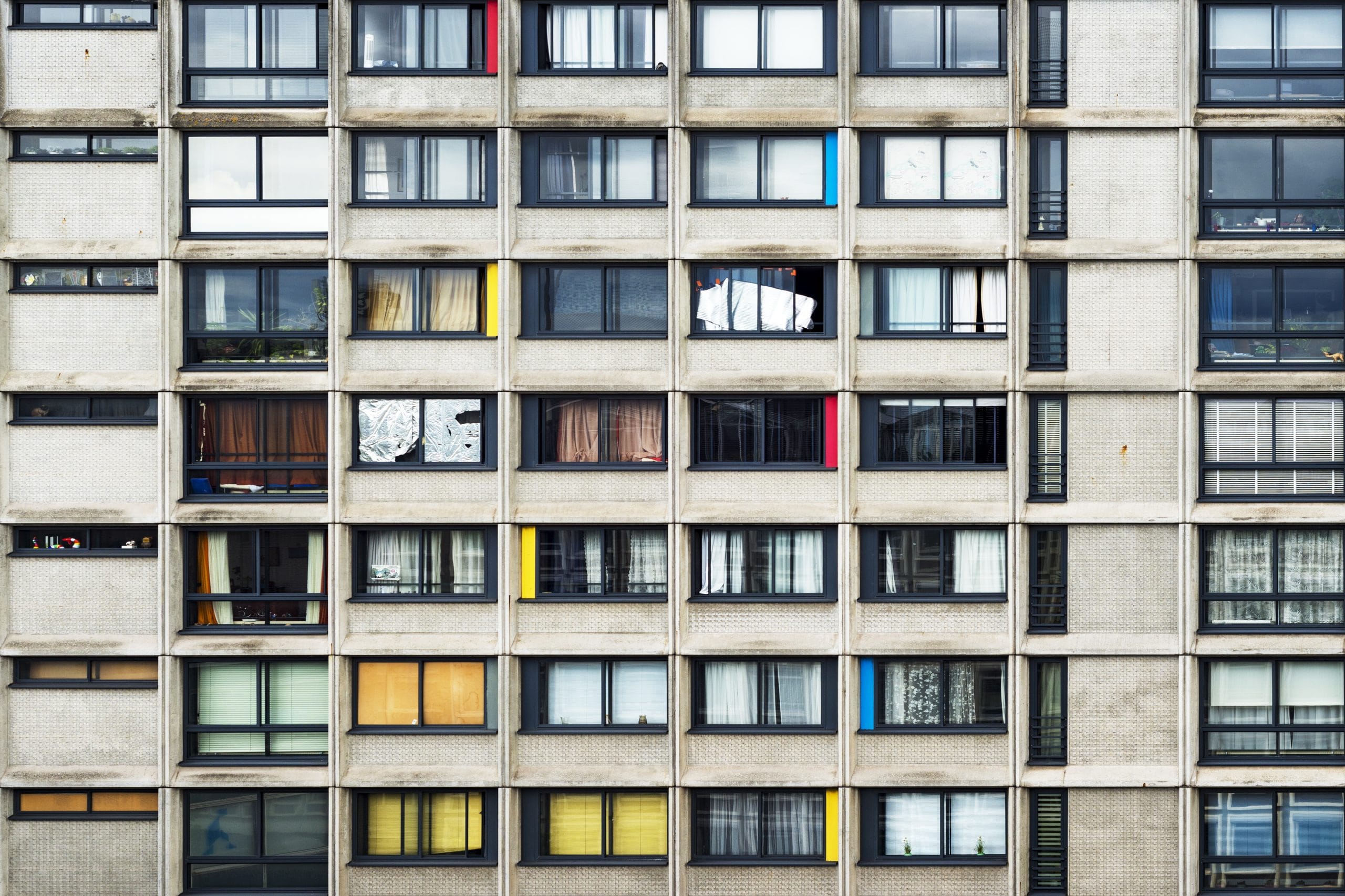 An apartment building with pinches of color in the middle of the city